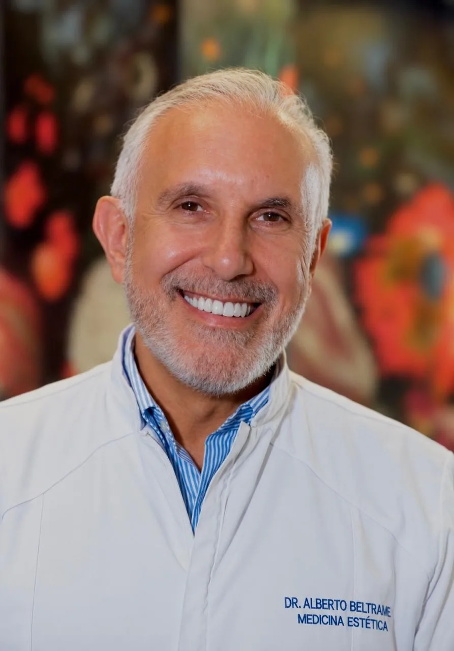 Dr. Alberto Beltrame, de jaleco branco, sorrindo